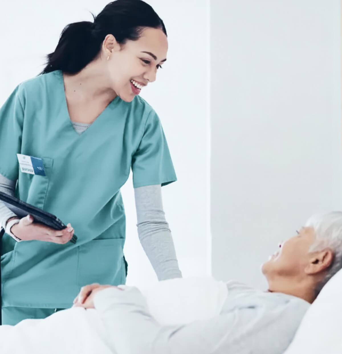 A physician in scrubs greets a patient in bed, ready for her CVAC System kidney stone treatment